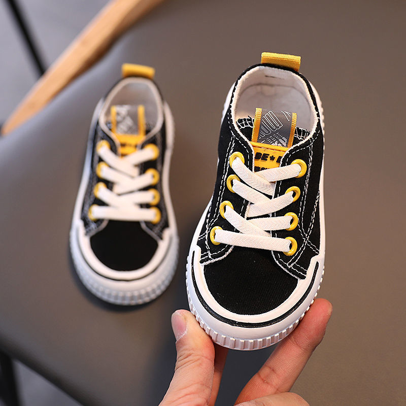 Children's canvas shoes in three colors: black, orange, and green, designed for boys' casual wear.