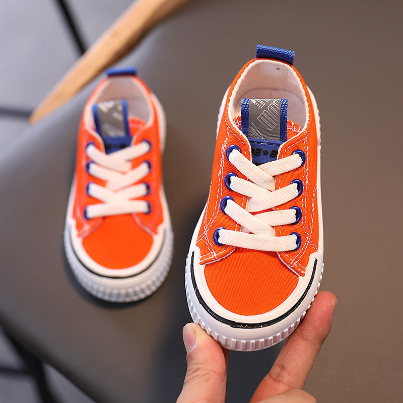 Children's canvas shoes in three colors: black, orange, and green, designed for boys' casual wear.