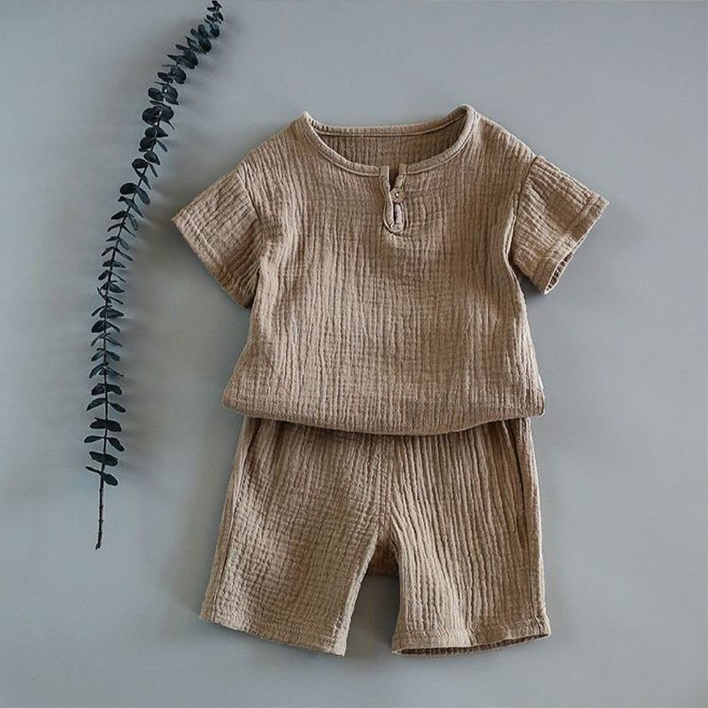 Baby short-sleeved summer outfit in earthy tones hanging on hooks, perfect for warm weather comfort.