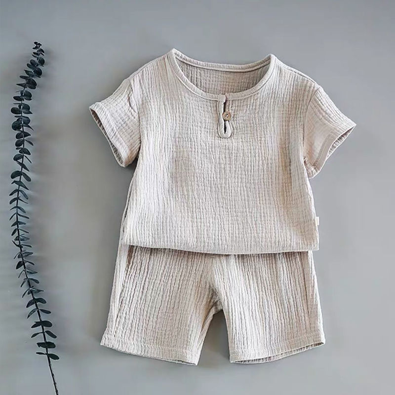 Baby short-sleeved summer outfit in earthy tones hanging on hooks, perfect for warm weather comfort.