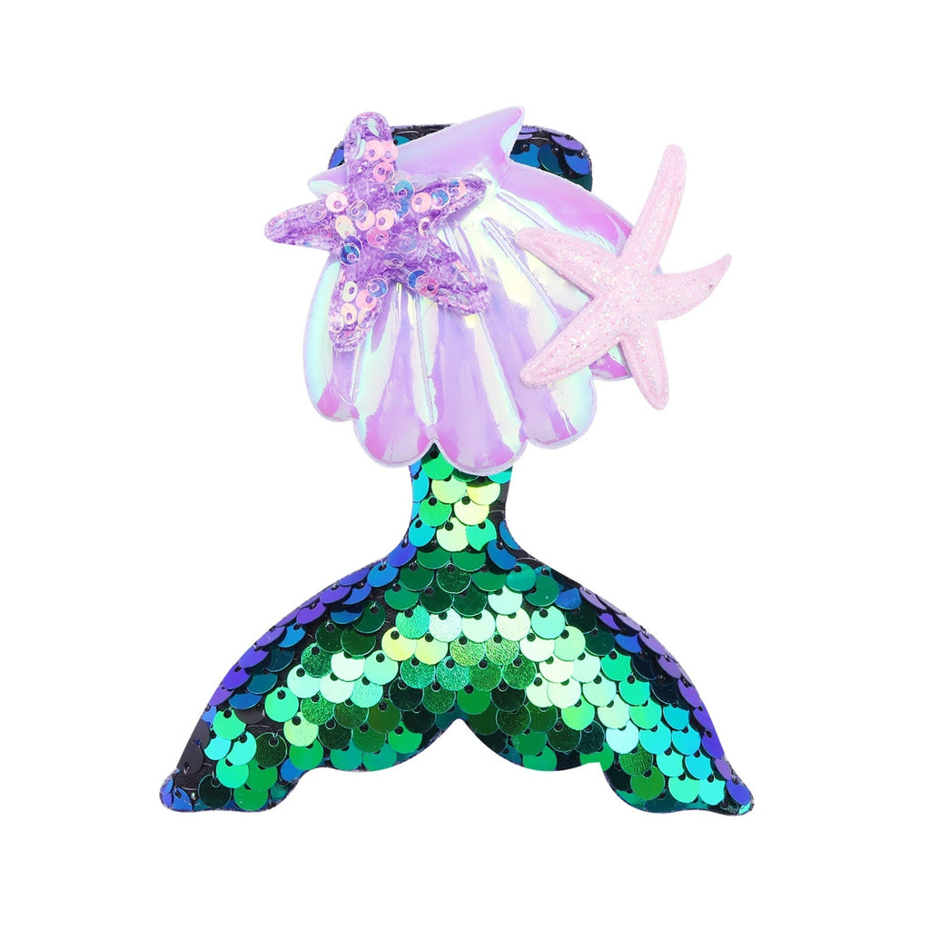 Colorful mermaid tail barrettes displayed on a table, featuring starfish designs and shimmering sequins for girls' hair.
